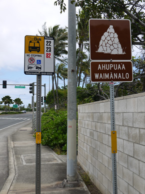 クリオウオウ ビーチパークに近いバス停「Kalanianaole Hwy + Opp Kawaihae St」。右側の白い壁の向こうに小径があり、そのまま海の方へ向かって行くと公園があります。